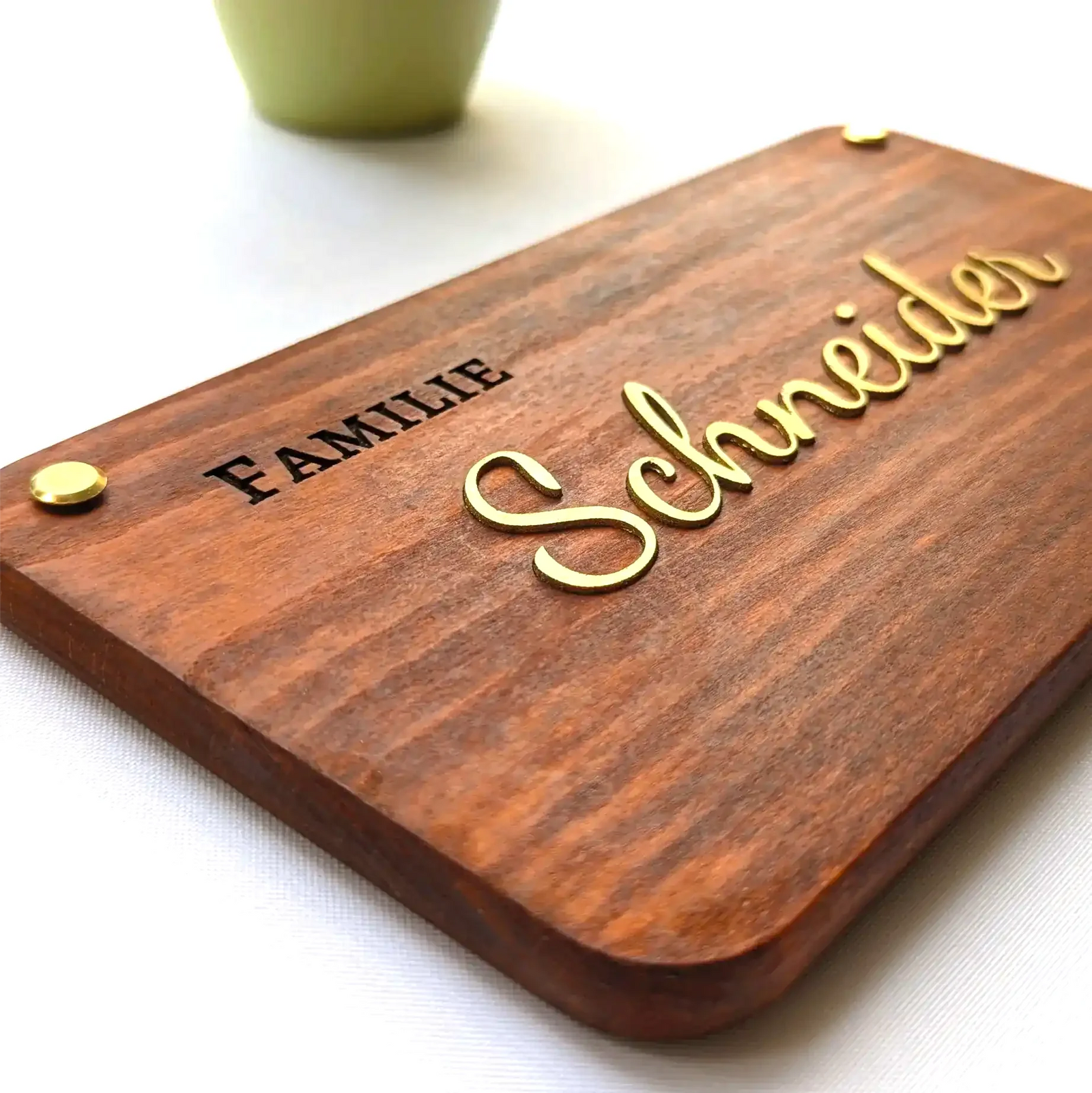 Nahaufnahme eines personalisierten Holzschilds mit erhabenen Lederbuchstaben