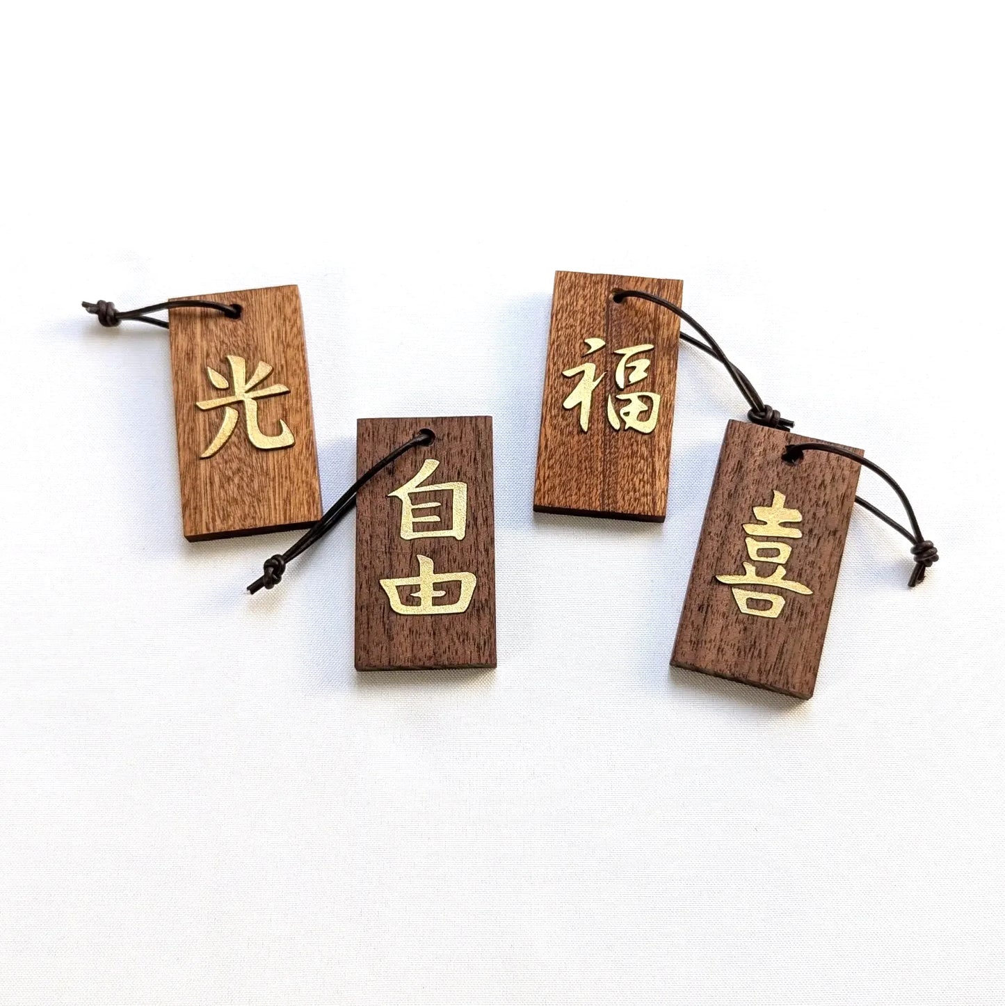Kanji Mini Talisman – handgefertigter Holz Anhänger-Glücksbringer mit vergoldeter Lederprägung