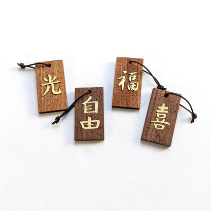 Kanji Mini Talisman – handgefertigter Holz Anhänger-Glücksbringer mit vergoldeter Lederprägung