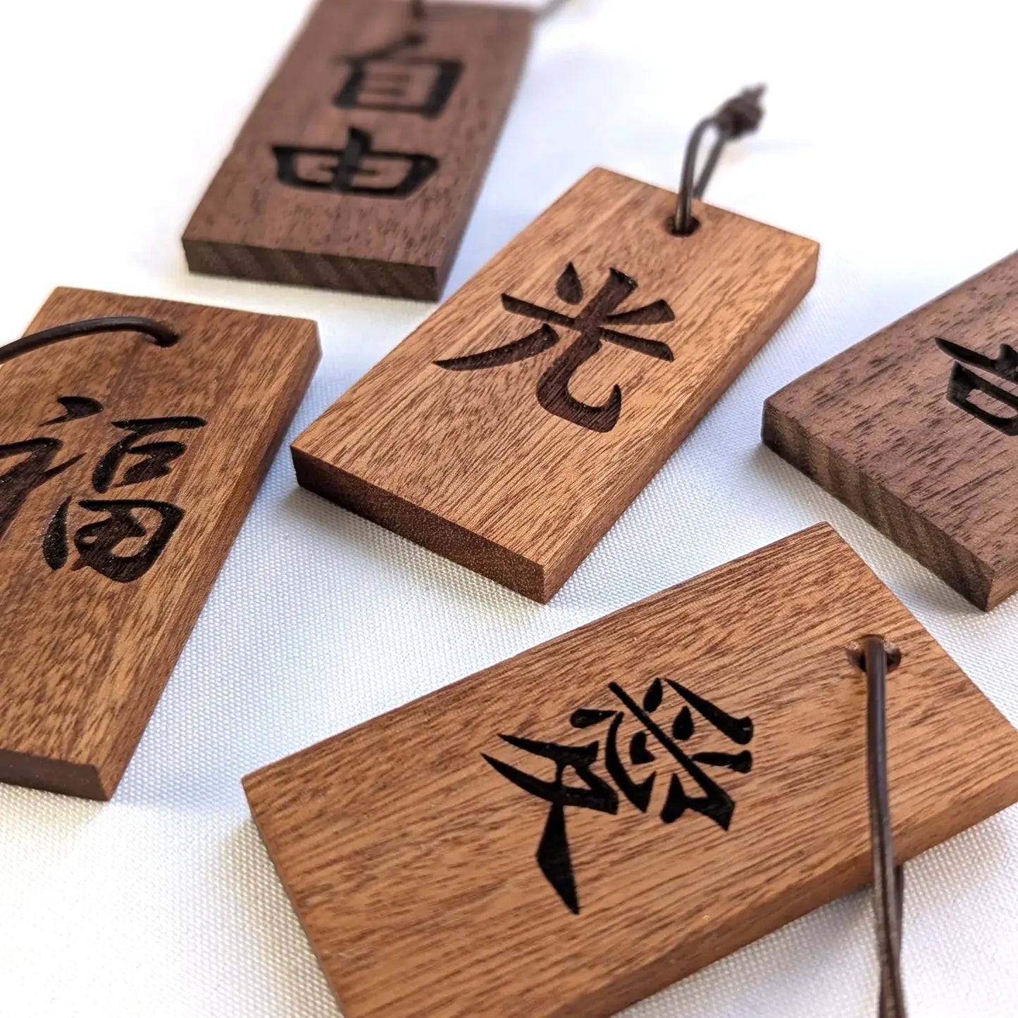 Kanji Mini Talisman – handgefertigter Holz Anhänger-Glücksbringer mit vergoldeter Lederprägung