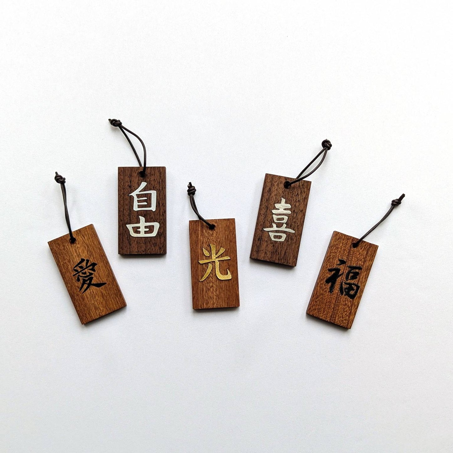 Kanji Mini Talisman – handgefertigter Holz Anhänger-Glücksbringer mit vergoldeter Lederprägung