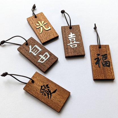 Kanji Mini Talisman – handgefertigter Holz Anhänger-Glücksbringer mit vergoldeter Lederprägung