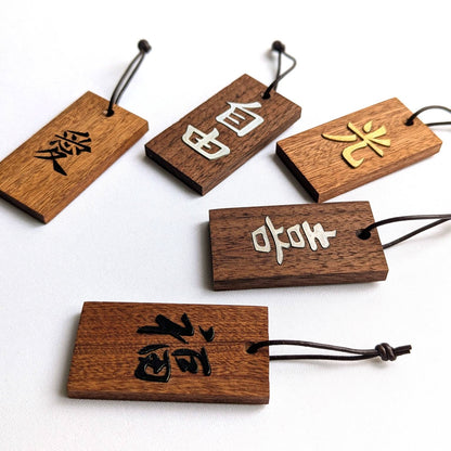 Kanji Mini Talisman – handgefertigter Holz Anhänger-Glücksbringer mit vergoldeter Lederprägung