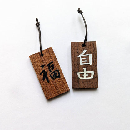 Kanji Mini Talisman – handgefertigter Holz Anhänger-Glücksbringer mit vergoldeter Lederprägung