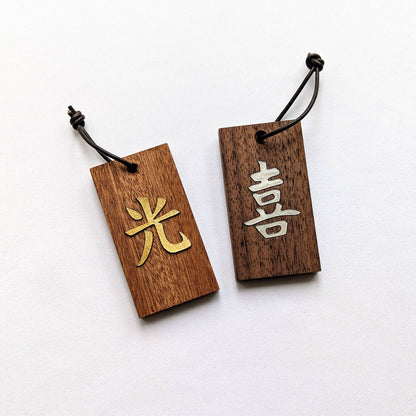Kanji Mini Talisman – handgefertigter Holz Anhänger-Glücksbringer mit vergoldeter Lederprägung