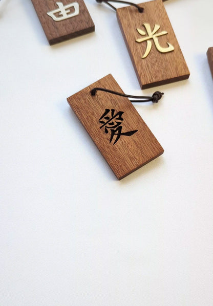 Kanji Mini Talisman – handgefertigter Holz Anhänger-Glücksbringer mit vergoldeter Lederprägung